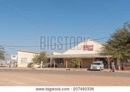KOES, NAMIBIA - JULY 5 2017: A street scene with a supermarket and people in Koes a small town in the Karas Region in Namibia