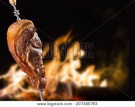 Alcatra traditional Brazilian barbecue. fire in background
