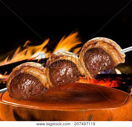 Picanha traditional Brazilian barbecue. fire in background