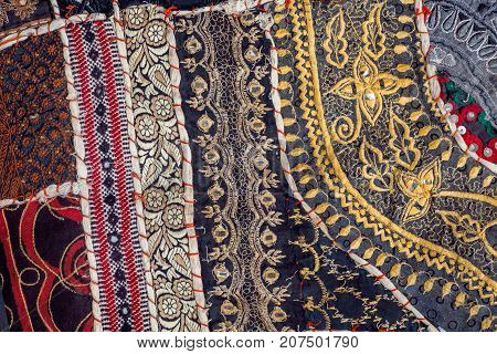 Vintage patchwork background on retro handmade carpet. Patterns on texture of old blanket surface.