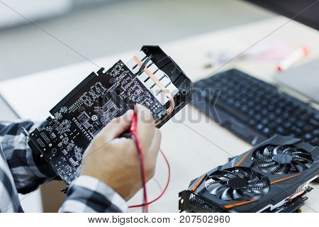 Close-up of a man who repairs a video card. Cryptocurrency. Business and finance concept.