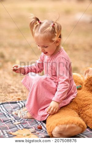 Close-up of a beautiful little girl in a pink dress playining in the fresh air