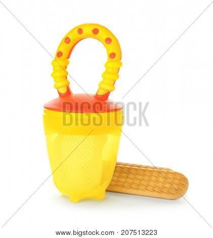 Baby's nibbler and cookies on white background