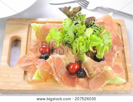 wood plate full of meat with fruit and salad