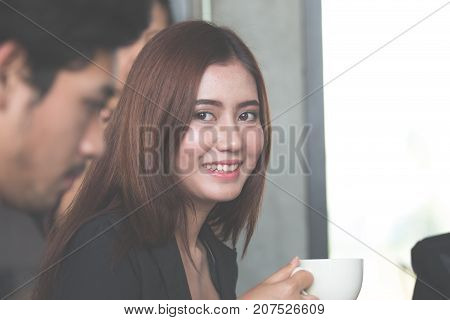Businesswoman drinking coffee / tea and using tablet computer in a coffee shop