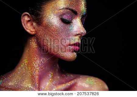Portrait of Beautiful Woman with Sparkles on her Face. Girl with Art Make-Up in Color Light. Fashion Model with Colorful Makeup
