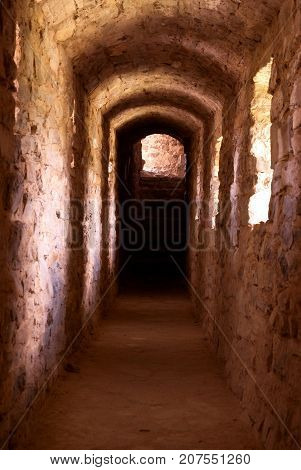 Interiors of castle, view through the stone tunnel with windows