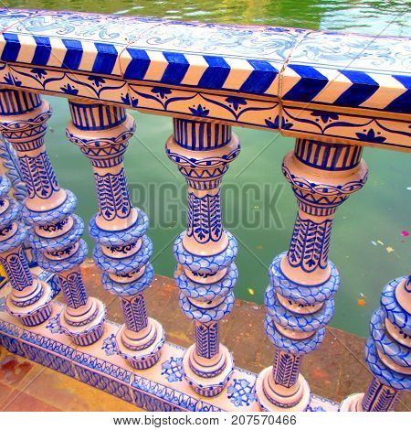 promenade in seville details on poles covered with mosaics ( spain )