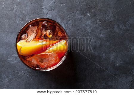 Negroni cocktail on dark stone table. Top view with space for your text