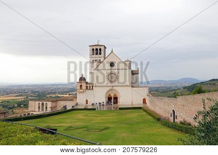 ASSISI ITALY 30 JUNE 2017: Famous Basilica of St. Francis of Assisi (Basilica Papale di San Francesco) with Lower Plaza at sunset in Assisi Umbria Italy