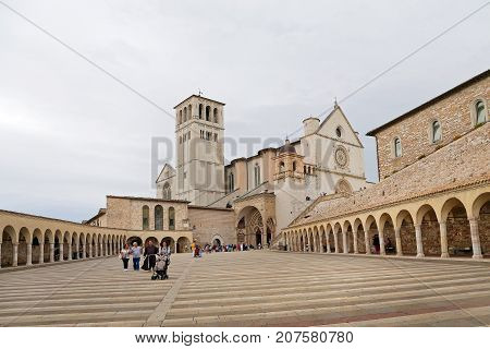 ASSISI ITALY 30 JUNE 2017: Famous Basilica of St. Francis of Assisi (Basilica Papale di San Francesco) with Lower Plaza at sunset in Assisi Umbria Italy