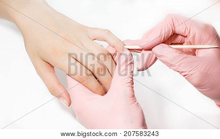 The master does a manicure to a girl. Close-up on a white background.
