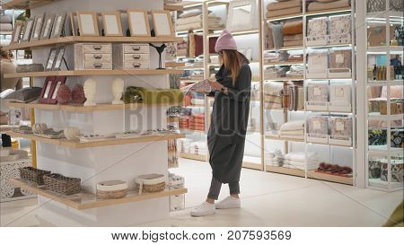 MINSK, BELARUS - OCTOBER 10, 2017. Inside Zara Home retail store in Minsk. A young hipster woman chooses home acessories the store. Shopping