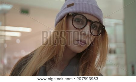 A young hipster female portrait in the store near shop windows