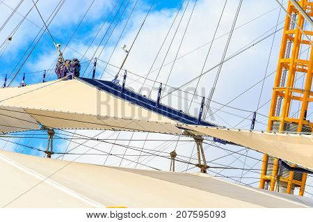 A Group Of People Climbing The Top Of O2 Dome In North Greenwich