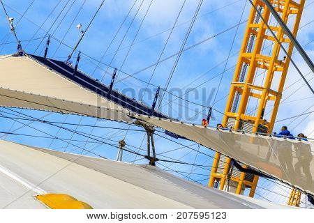 A Group Of People Climbing The Top Of O2 Dome In North Greenwich