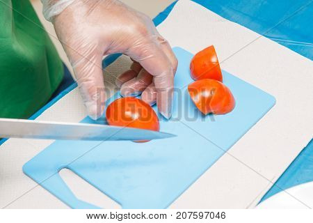 Chef Hand and Knife Slicing or cutting red Tomatoes