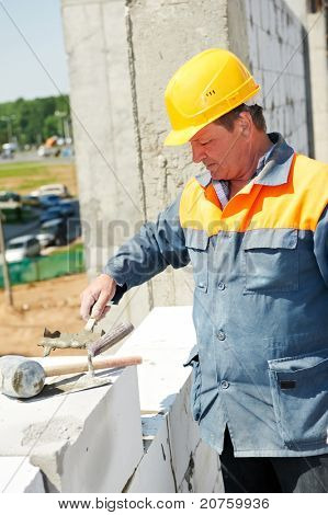 pedreiro de trabalhador de pedreiro de construção fazendo uma alvenaria com argamassa de cimento e espátula
