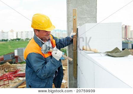 pedreiro de trabalhador de pedreiro de construção instalação do tijolo de silicato de cálcio por martelo batendo trabalho