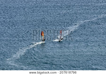 Two windsurfers on the waves of the Mediterranean sea at Cape Prasonisi Rhodes (Greece)