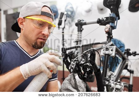Mechanic repairing bicycle in his workshop. Bicycle service.
