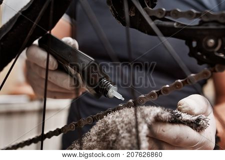 Closeup Cleaning and oiling a Bicycle chain and gear with oil