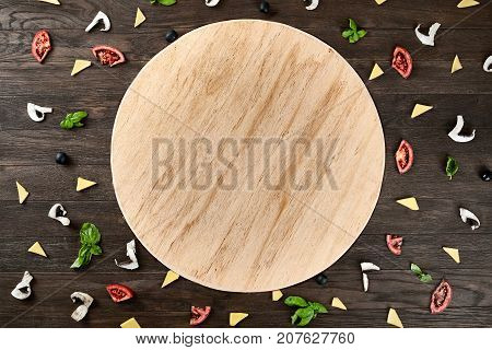 Four cheese pizza quattro fromaggi on a rustic wooden board on the table with ingridients. Selective fovus