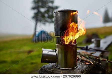 Cooking in a pot over the firewood stove. Foggy rainy weather on background