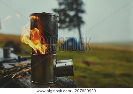 Cooking in a pot over the firewood stove. Foggy rainy weather on background