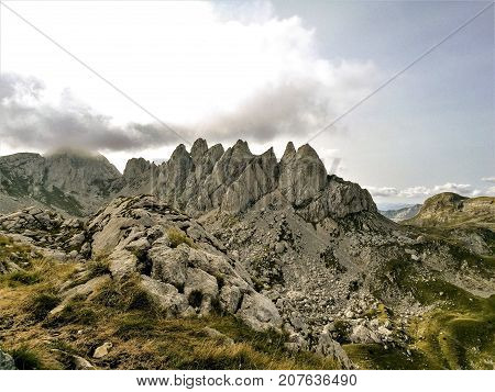 Mountain in Montenegro with clouds and meadow