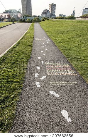 Colorful painted museum sign on asphalt pavement of plaines d'Abraham Road to the Museum at the Citadelle of Quebec City, Canada