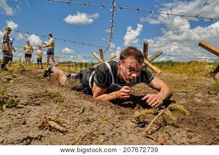 Tyumen, Russia - July 1, 2017: Race of Heroes project on the ground of the highest military and engineering school. People passing under a barbed wires or climbing obstacles