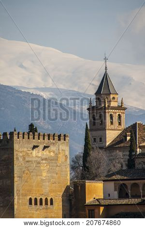 Famous view of the Alhambra in Granada, spain, with the mountains of Sierra Nevada in the background. The Alhambra is a UNESCO World Heritage Site and the inspiration for many songs and stories
