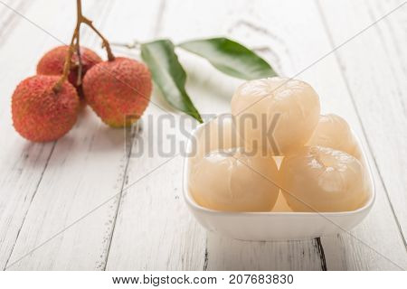 peeled lichee in front with some fresh unpeel ones on back