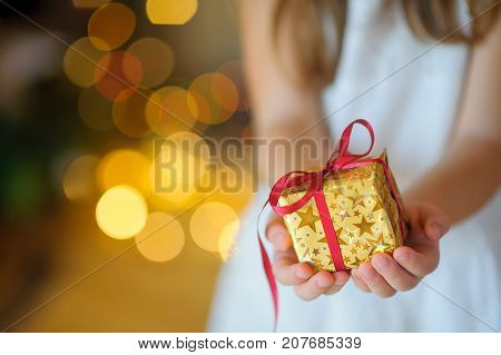 Child Gently Holds In The Hand A Christmas Gift