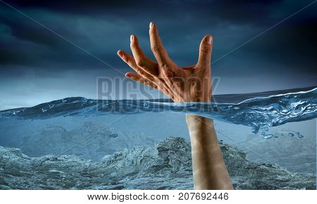 Hand of person drowning in water