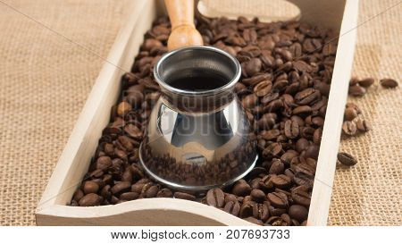 Coffee grains and coffee gezve. Strong coffee. Coffee mug. Coffee break. Brown image