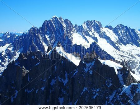 Alpine mountains range landscape in beauty French Italian and Swiss ALPS seen from Aiguille du Midi at CHAMONIX MONT BLANC in FRANCE with clear blue sky in 2016 warm sunny summer day Europe on July.