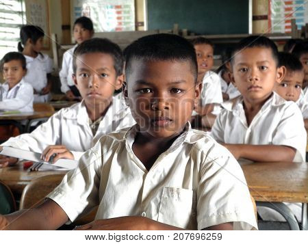 Seam Reap, Cambodia: October 08, 2012: Close up of a Cambodian school boy at his desk. The school is named New Bridge for Cambodia and is an organization that offers students free education.