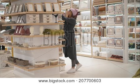 MINSK, BELARUS - OCTOBER 10, 2017. Inside Zara Home retail store in Minsk. A young hipster woman chooses home acessories the store. Shopping