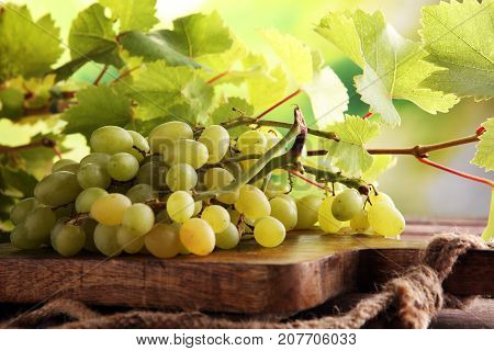 Grapes on wooden table and grape leaves . Healthy fresh fruit wine grapes.