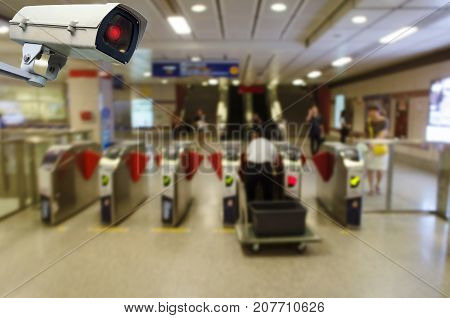 CCTV security indoor camera system operating with blurred image of staff working at entrance of subway or railway at train station transportation surveillance security and safety technology concept