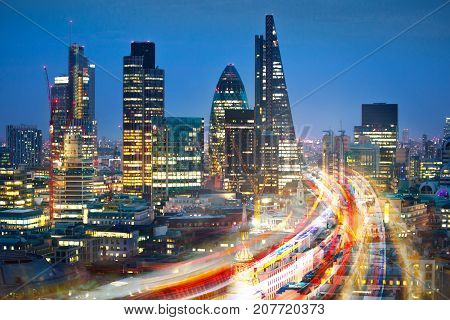 City of London view at sunset and busy road with transport blurred lights. Success, transformation and innovation idea.