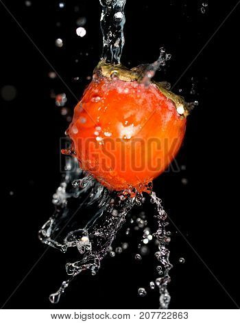 persimmon in water on a black background