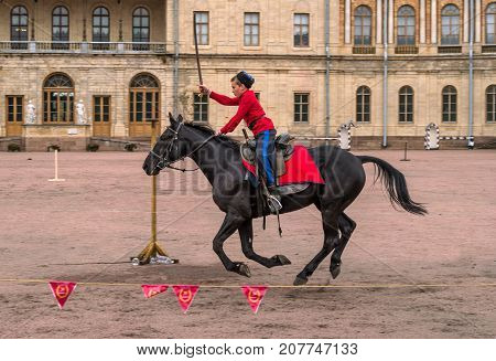 Gatchina St. Petersburg Russia - September 30 2017: Horse show of Cossacks on the parade ground of the Gatchina Palace. The young Cossack performs tricks on the horse.