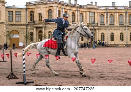 Gatchina St. Petersburg Russia - September 30 2017: Horse show of Cossacks on the parade ground of the Gatchina Palace. The Cossack rides with a sword.