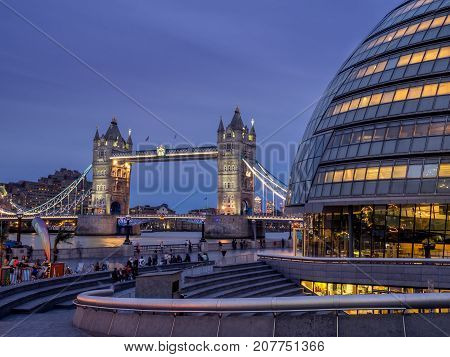 LONDON UK - AUG 1: London City Hall and Tower Bridge on August 1, 2017 in London UK. The City Hall has an unusual bulbous shape was designed by Norman Foster and opened in July 2002.