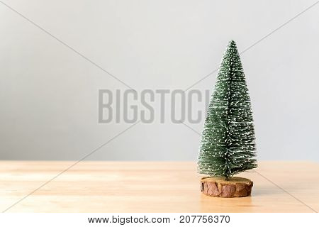 Christmas tree on wood table with white wall background Christmas holiday celebration concept Copy space