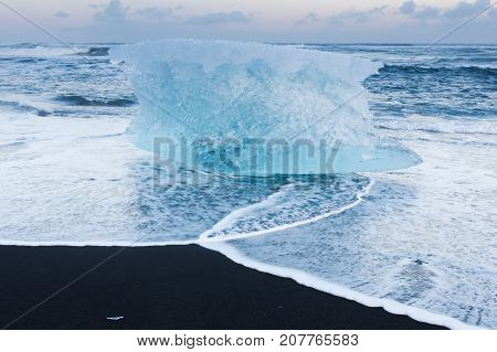Natural freezing iceberg over black sand beach Iceland winter season natural landscape background