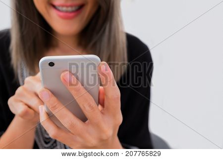 A happy lady is using cellphone isolated on white background.